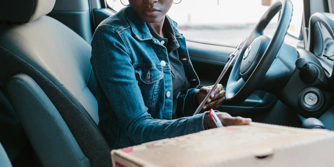 Delivery driver with pizzas in her car